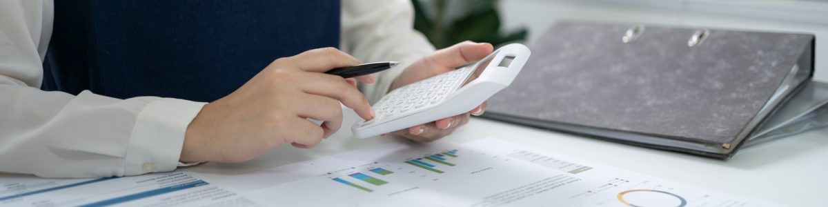 Businesswoman Accountant analyzing investment charts Invoice and pressing calculator buttons
